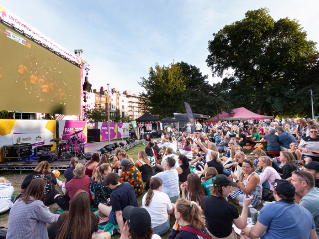 Picture of rugby fans watching a match on the giant screen at the Victoria Gardens Fan Zone