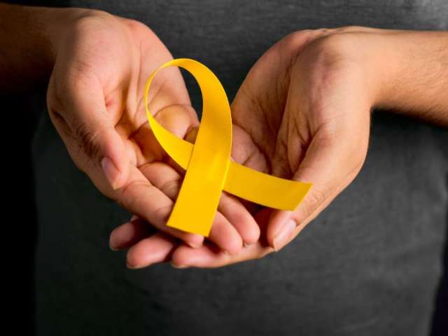 Hands holding a yellow ribbon