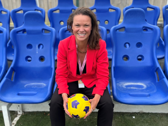 Councillor Bella Sankey holding a football sat on a blue bench