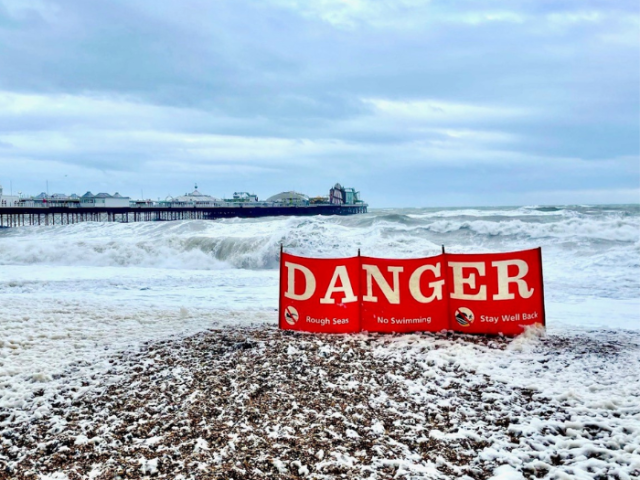 Photo of a red Danger sign taken on a windy day on Brighton beach
