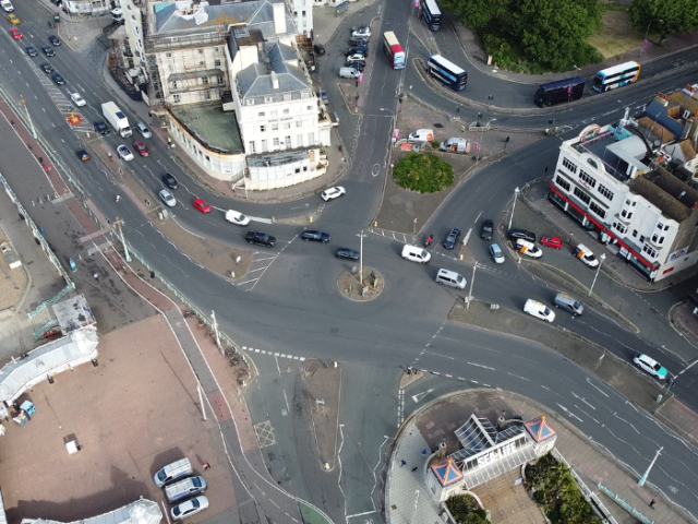 An arial photograph of a roundabout with cars and buildings surrounding it