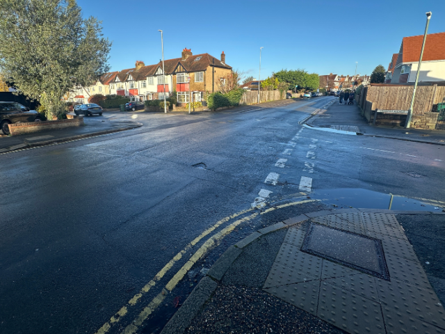 A photo of a road junction with houses in the background