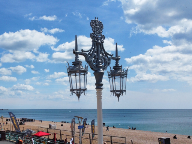 A decorative streetlight in front of a blue sky and white clouds