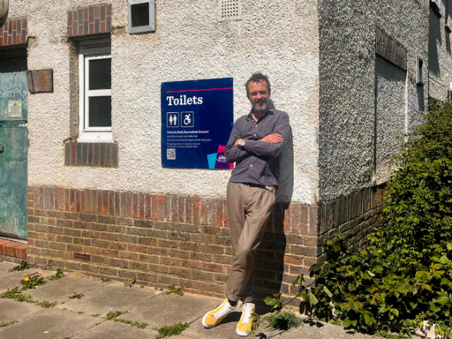 Cllr Rowkins leaning against the Victoria Rec toilet block.