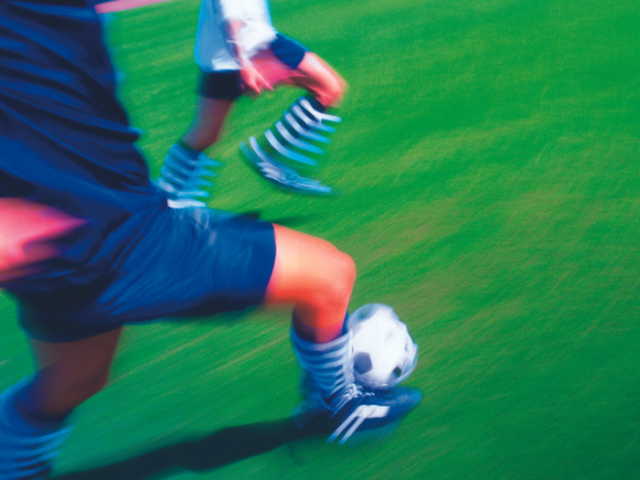 photo depicts people playing football in motion