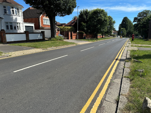a resurfaced road with double yellow lines
