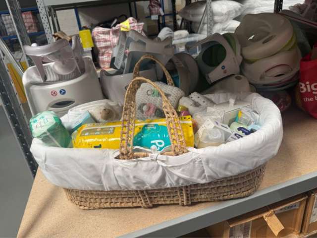 A Moses basket of baby essentials placed on a shelf