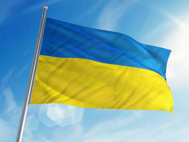 Picture shows a blue and yellow Ukrainian flag flying on a sunny day.