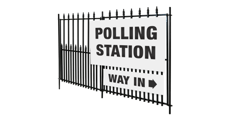 Polling station sign on a railing with an arrow pointing to the way in.