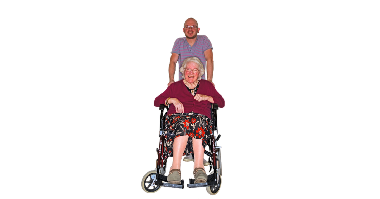 Person caring for an older person in a wheelchair.