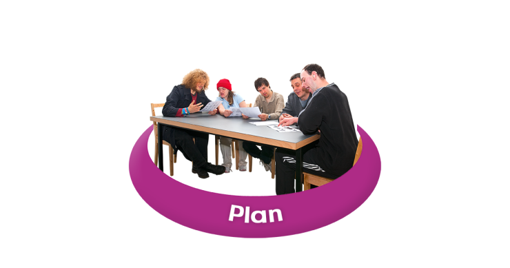 Group of people sitting around a table making a plan.