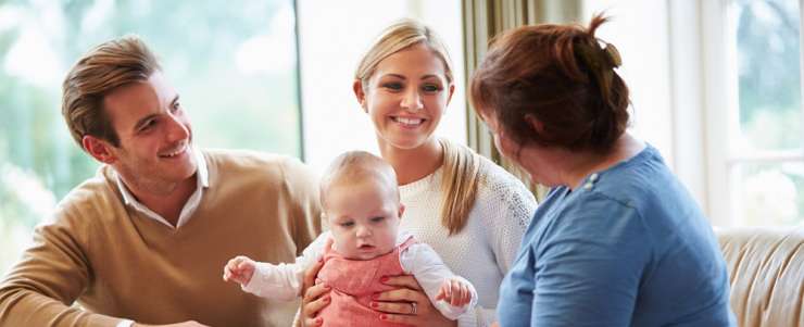 A family talking to a health visitor on a sofa
