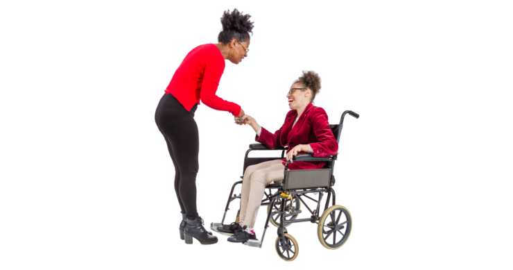 Woman standing shaking the hand of a woman in a wheelchair.
