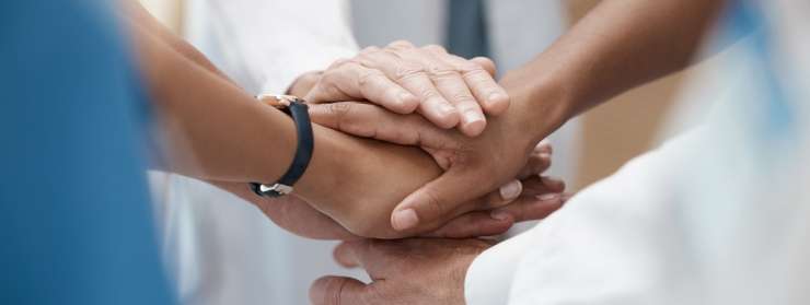 hands placed on top of each other in a group circle