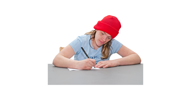 Person sitting at a desk writing.