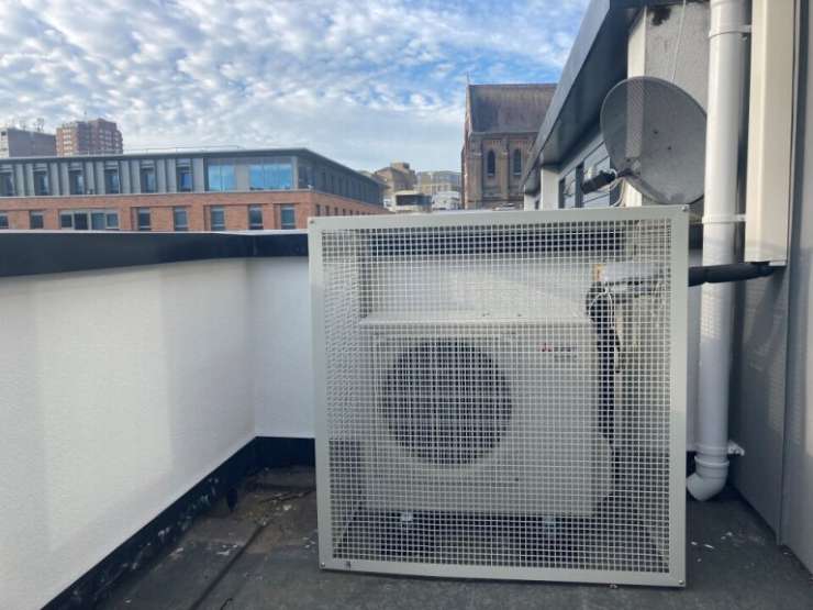A photograph of a roof top with a large extracter fan.
