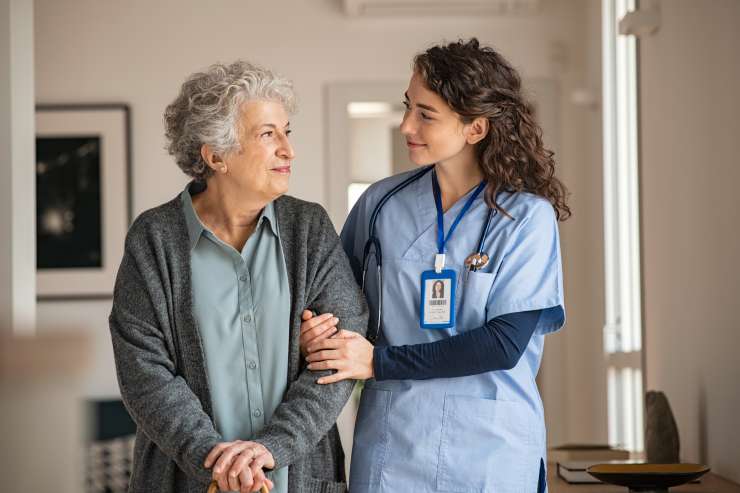 A carer holding the arm of an older person 
