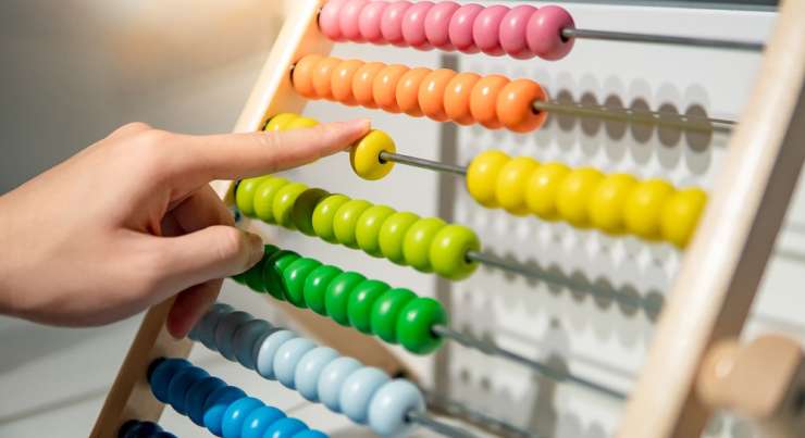 hand moving beads on an abacus