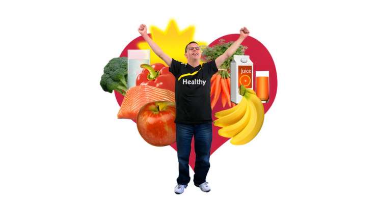 Person looking happy standing in front of lots if healthy food and a red heart.