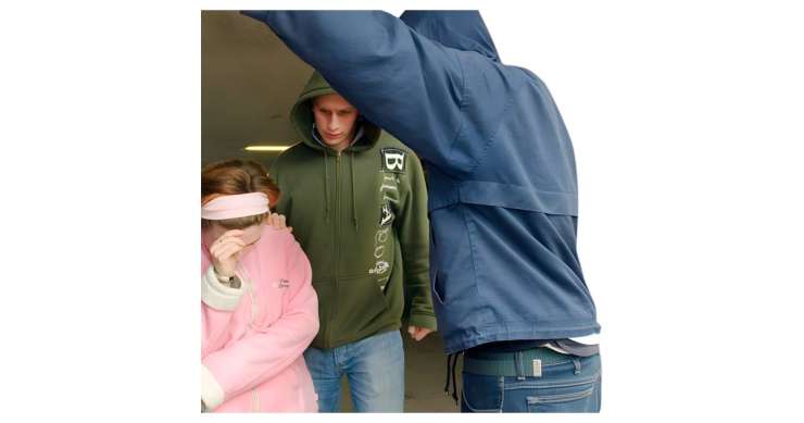 Woman being threatened by two people in hoodies
