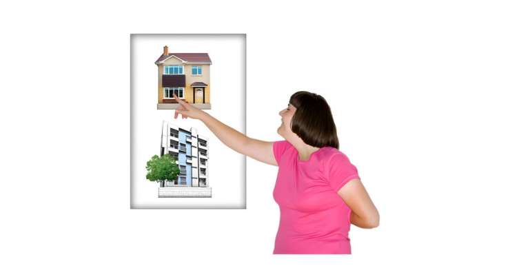 Person pointing to a picture showing a house and a block of flats. The person is choosing the house.