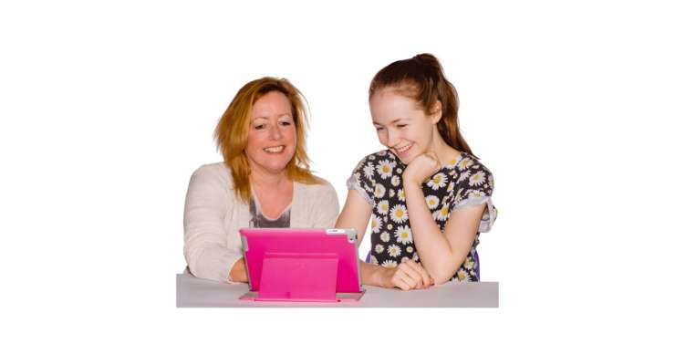 Adult helping a younger person with an iPad.