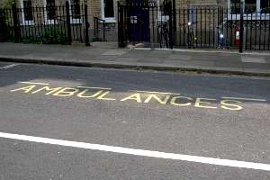 Photograph showing ambulance bay markings on a road, the markings are in bright yellow