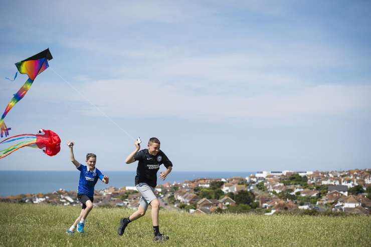 Children flying kites in the countryside.